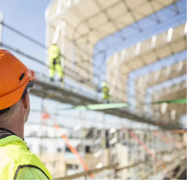 Construction site workers building a structure with stone design elements